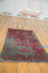 Frayed end and hard wear on a hand-knotted vintage Karaja rug, showing geometric red and blue.