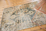 Distressed vintage Hamadan rug with faded sand and seafoam geometric motifs showing wear.