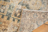 Distressed Hamadan rug with worn sand, ivory, green geometric pattern and visible hand-knotted foundation.