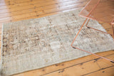 Vintage distressed Hamadan rug, showing knot heads and geometric patterns in ivory, camel, brown.