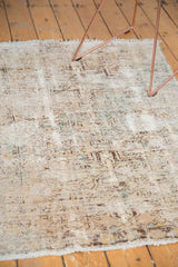 Distressed vintage Hamadan rug's worn foundation, knot heads, and faded ivory geometric patterns.
