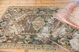 Decorative distressed Hamadan rug with geometric pattern, exposed foundation, and ivory, teal, brown colors.