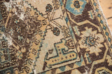 Distressed Hamadan rug's worn pile, geometric floral buds, dusty teal, and visible foundation.