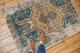 Distressed vintage Hamadan rug featuring faded teal, gold geometric medallion and noticeable surface wear.