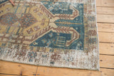 Distressed corner of the vintage Hamadan rug showing worn pile, faded teal and ivory tones.