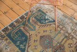 Worn texture, faded teal, gold, and brown geometric patterns on a vintage Hamadan rug.