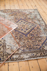 Textured vintage Hamadan rug with prominent wear, faded blush, and striking cobalt blue patterns.
