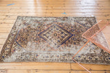 Distressed Hamadan rug corner with worn pile, herati motif, and blush, blue, ivory tones.