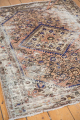 Worn knot heads and visible foundation on a distressed Hamadan rug.