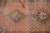 Distressed Hamadan rug close-up revealing pale rose, mint motifs, and exposed foundation.