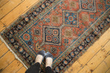 Hand-knotted antique Heriz rug corner: terra cotta field, sky blue motifs, floral navy border.