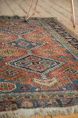 Antique Heriz rug's hand-knotted pile in terra cotta, blue, and ivory geometric patterns.