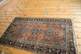 Antique Heriz rug runner with geometric diamond medallions, pinwheels, in terra cotta and blue.