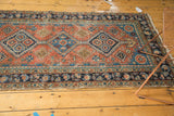 Antique Heriz runner with interconnected diamond medallions in terra cotta, navy, and sky blue.