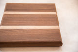 Contrasting light maple and dark mahogany wood grain on the thick handmade board.