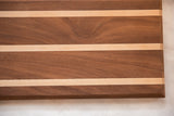 Mahogany and maple serving board showcasing natural wood grain and contrasting striped design.