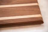 Close-up of thick mahogany and maple serving board's chamfered edge.