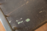 Antique Deacon's Bench surface features dark crackled paint and pale green chips.