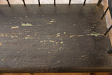 Antique Deacon's Bench seat with dark, crackled paint revealing green and wood layers.