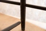 Broken bottom rail and chipping dark paint on an antique Deacon's Bench leg.
