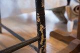 Dark painted leg of antique Deacon's Bench with extensive chipping revealing light undercoat.