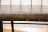Antique Deacon's Bench with cracked black paint and exposed wood on the seat edge.