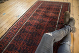 Antique Belouch rug with bold geometric gul pattern in madder red, navy, and charcoal.