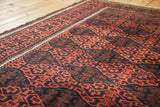 Soft textured wool and geometric gul motif in madder root red and navy on an antique Belouch rug.