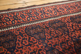 Soft wool texture with geometric gul motifs in madder root red and navy blue.