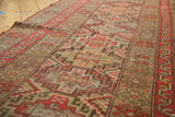 Geometric diamond-stepped medallions and time-softened red-orange, camel hues on this Antique Kurdish runner.