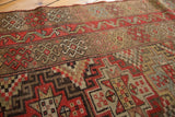 Antique Kurdish runner showing geometric patterns, red-orange tones, and mostly even wear.