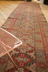 Repeating diamond stepped medallions in bright red orange, camel, and antique ivory on a Kurdish rug.