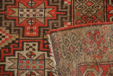 Kurdish hand-knotted runner's geometric pile in red-orange, brown, ivory and visible foundation.