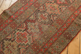 Geometric stepped diamond medallions in red-orange, camel, brown, with mostly even pile wear.