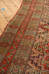 Textured antique Kurdish runner with geometric diamond medallions, red-orange and camel.