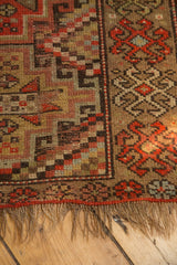 Antique Kurdish runner end, with worn fringe and geometric stepped patterns in earthy tones.