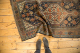 Folded antique Kamseh runner showing geometric scale pattern, copper, and dark blue tones.