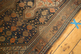 Copper scale design motif in dark blue field of this antique Kamseh rug with intricate border.