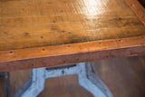 Industrial riveted copper edging detail on reclaimed wood tabletop.