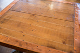 Reclaimed wood tabletop detail, showing visible grain and copper edging with rivets.