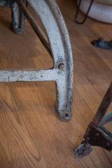 Close-up of the table's industrial bronze base with distressed white paint and rustic patina.