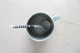 Large Ceramic Spoon Grey, with black and white striped handle in a matching mug.