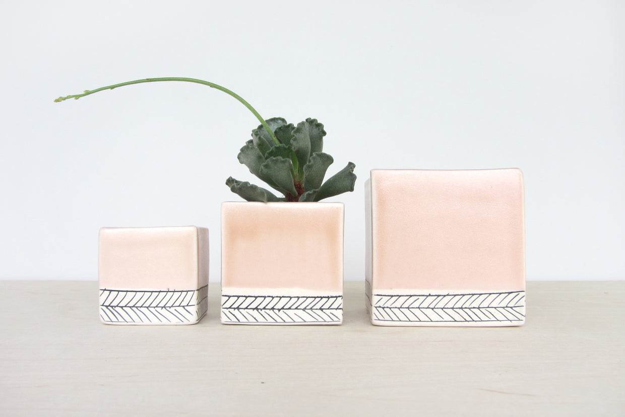 Small peach ceramic planter featuring a black herringbone pattern, 2x2x2.