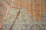 Detail of vintage distressed Oushak rug, showing blush peach, ivory, mint, and pale blue patterns.