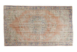 Distressed vintage Oushak carpet; rococo medallion, arabesque field, blush, ivory, mint, and pale blue.