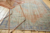 Distressed Oushak rug texture, showing faded blush peach, mint, and blue hues.