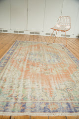 Distressed vintage Oushak carpet pile texture and fringe in blush peach and pale royal blue.