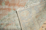 Hand-knotted vintage Oushak rug detail showing distressed blush peach pile and woven foundation.