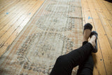 Distressed vintage Oushak runner displaying blush rose, ivory, worn pile, and scrolling ram's horn motifs.