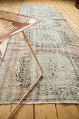Distressed vintage Oushak rug runner texture with visible knot heads in blush, charcoal, ivory.